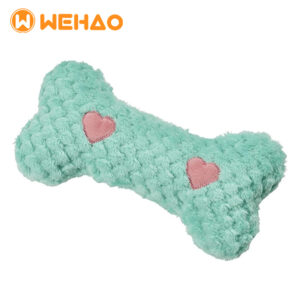 Mint green textured plush bone dog toy with pink hearts, featuring lavender scent and microwaveable heat pouch for anxiety relief, branded with Wehao logo.