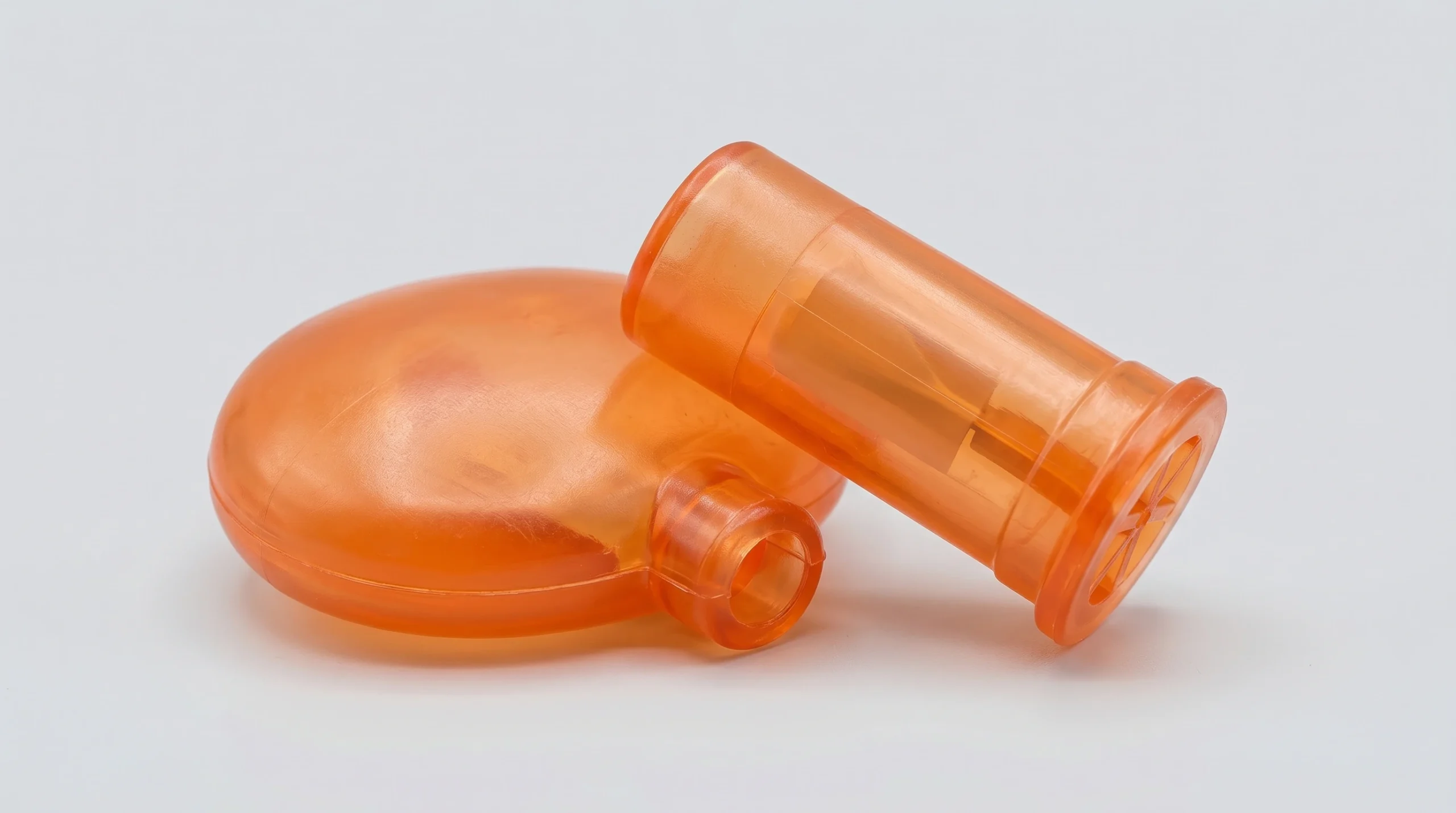 A close-up view of a raw, translucent orange food-grade TPR/EVA squeaker mechanism, designed to be puncture-resistant for durable pet toys.