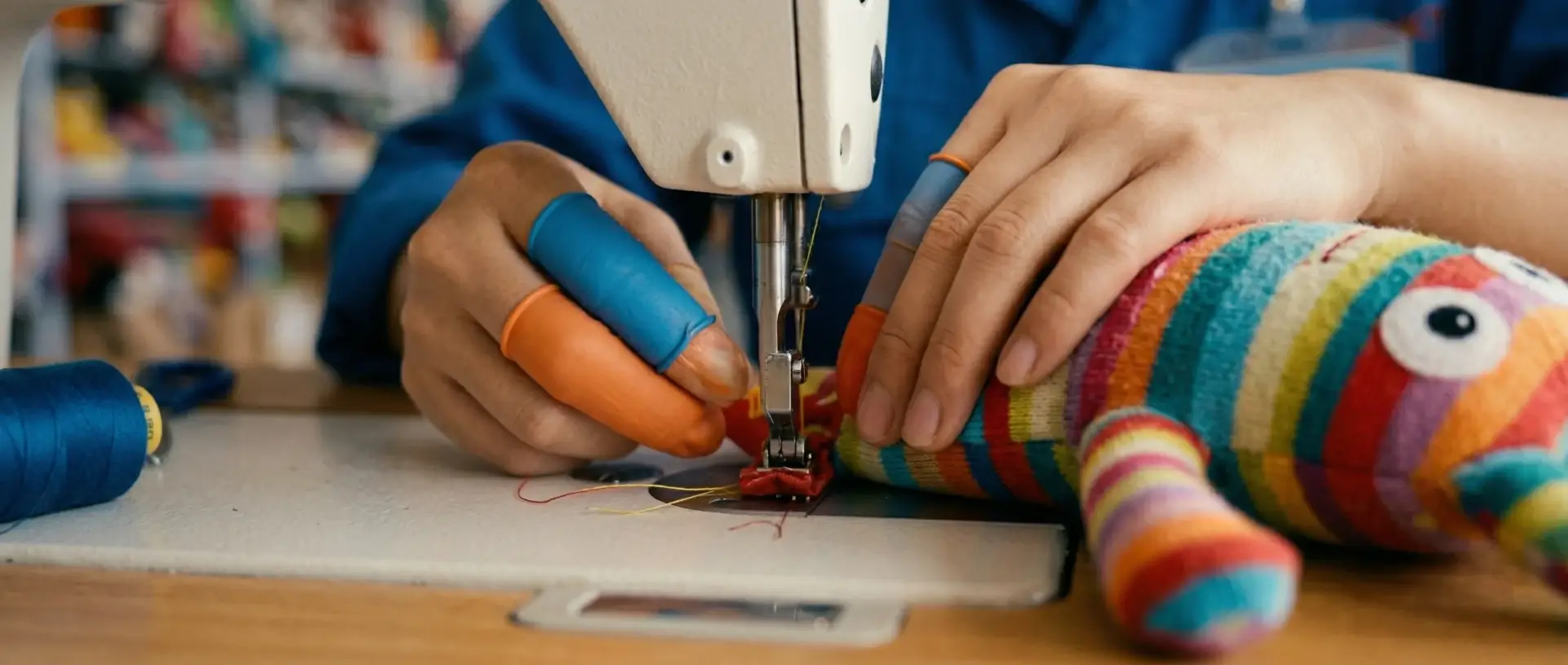 Master artisan sewing a custom pet plush toy in a clean, modern manufacturing facility